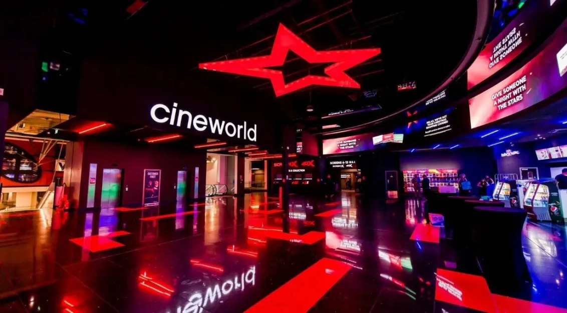 The modern, brightly lit foyer of the Cineworld cinema inside The O2 Belfast, featuring a glossy black floor reflecting red neon lights, digital screens and a large red star on the ceiling.