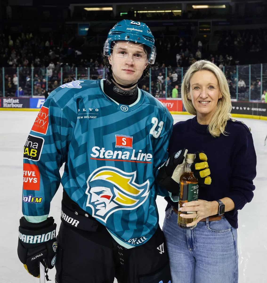 Hockey player holds up sponsor gift after winning Player of the Match.