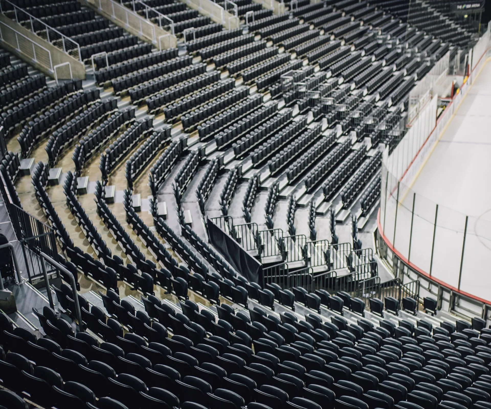 Tiered rows of arena seats positioned beside the ice rink at The O2 Belfast.