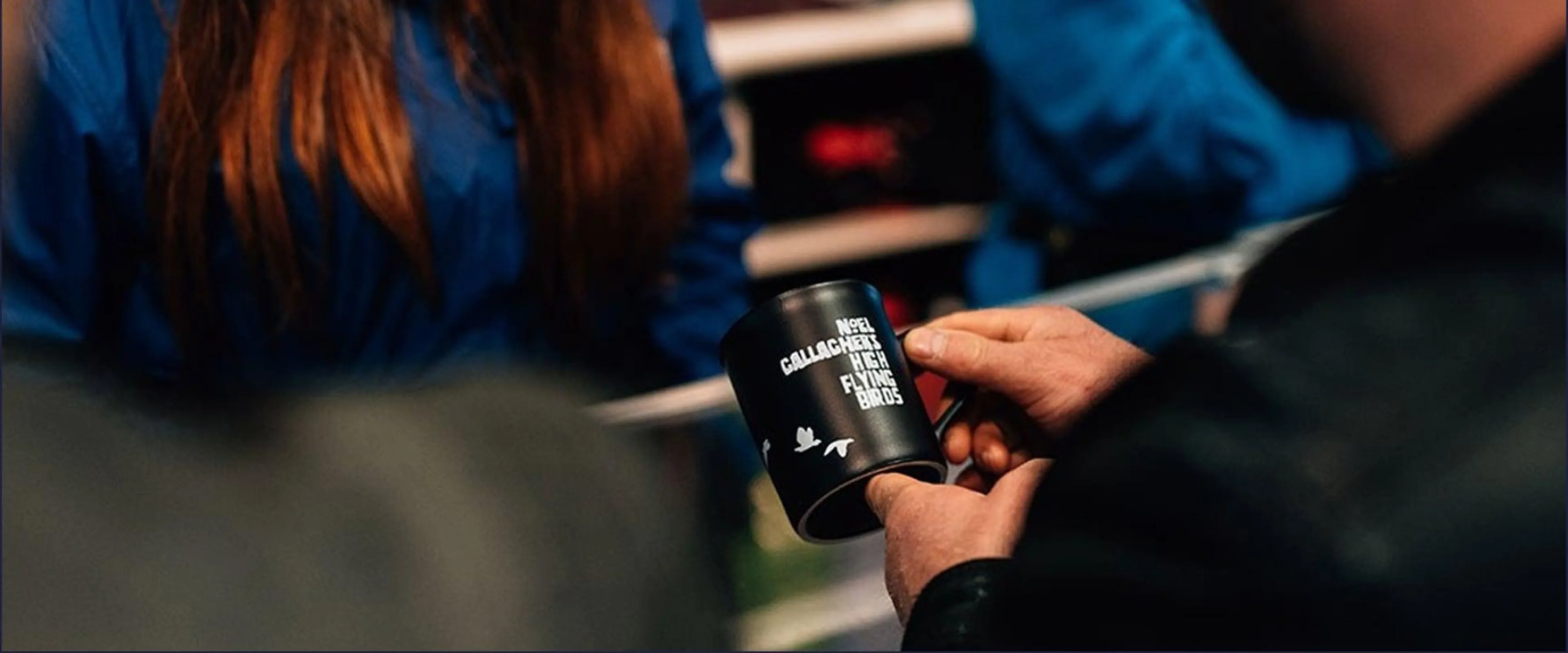 Customer looking at mug as part of the merchandise stand before a show.