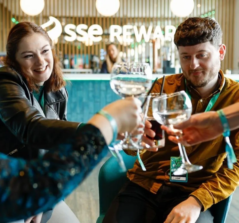Guests raise drinks together in the Reward Lounge, a premium hospitality space within The O2 Belfast.